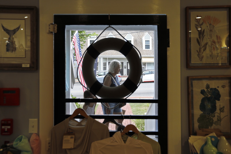 A woman walks past the front door of Dahlia Living, as seen from the inside of the boutique shop on Elm Street in Dartmouth, MA.  PHOTO PETER PEREIRA