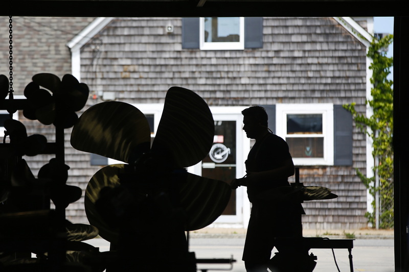 A technician works on repairing a large fishing boat propellor at the Fleet Propellor workshop in Fairhaven, MA. PHOTO PETER PEREIRA