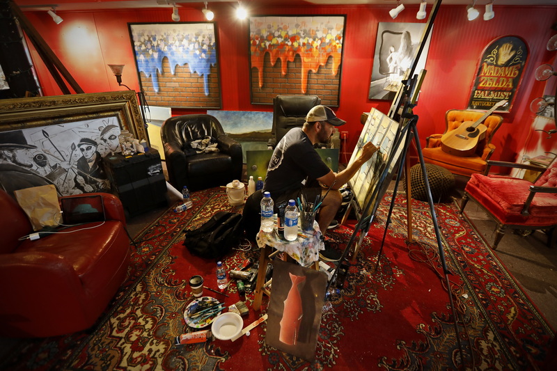 Ryan Mcfee works on a new commissioned painting of a waterfront scene, at his studio/gallery on William St. in downtown New Bedford, MA. PHOTO PETER PEREIRA