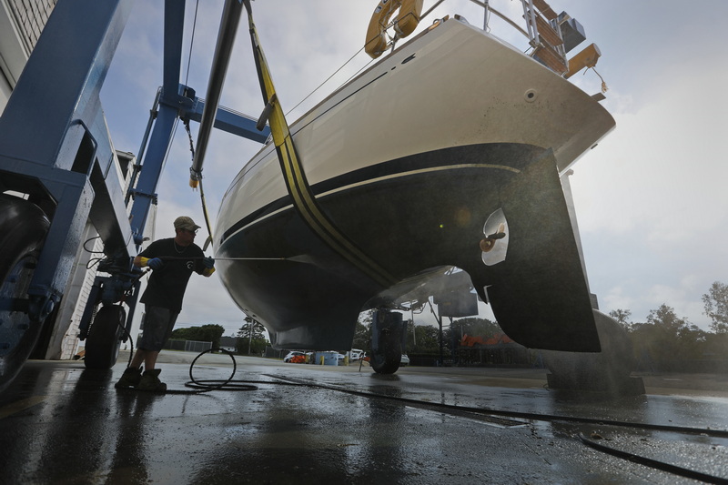 John Ellis powerwashes a sailboat just pulled out of the water for the season, before putting into storage at Concordia in Dartmouth, MA. PHOTO PETER PEREIRA