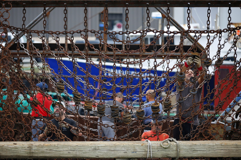 Fishermen aboard the Georges Bank fishing boat, make repairs to the scallop dredges before heading back out to sea from New Bedford, MA. PHOTO PETER PEREIRA