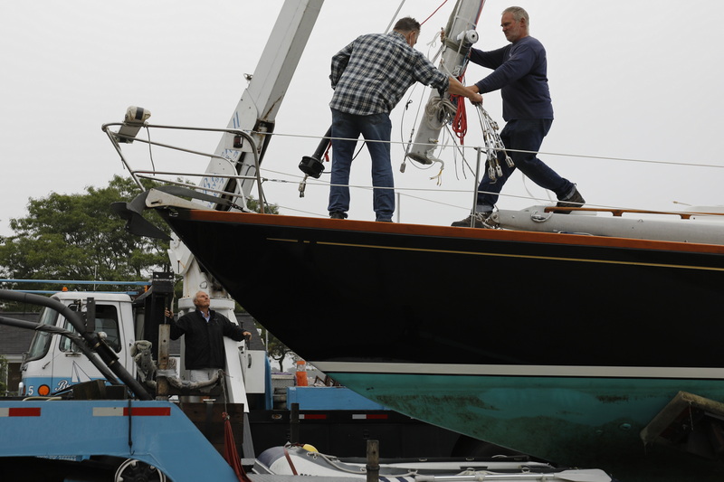 Tom Brownell, owner of Brownell Systems, operates the winch as his crew removes the rigging from a sailboat they are pulling out of the water in Mattapoisett, MA. PHOTO PETER PEREIRA