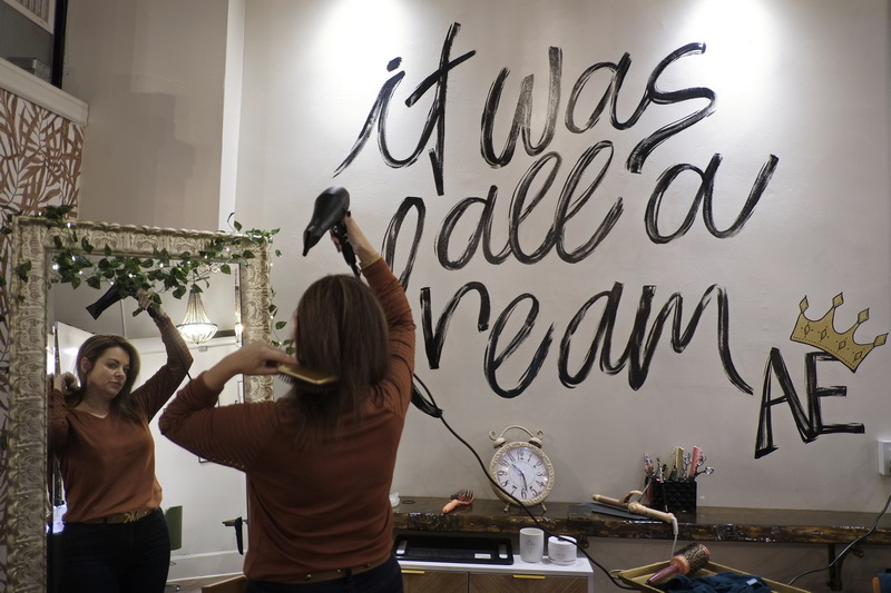 April Moses, owner of April Evans Beauty Lounge, is reflected on a large mirror as she combs her hair in preparation for another day of work at her downtown New Bedford boutique, gift shop. PHOTO PETER PEREIRA