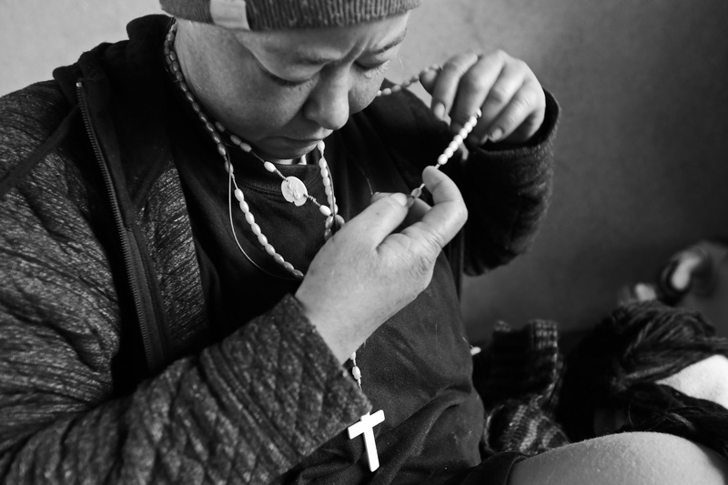 Amanda prays the rosary given to her by the Franciscan friars after getting up from the sidewalk where she slept overnight at a closed bank drive-thru in downtown New Bedford, MA.  Amanda has been homeless for the last ten years and is dealing with addiction. PHOTO PETER PEREIRA