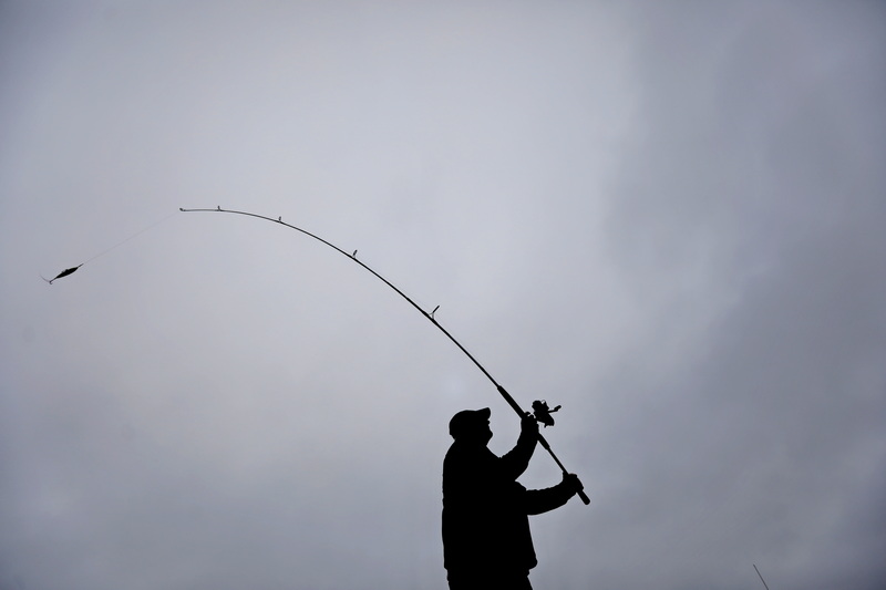 Henry Mitchell hopes to catch some bass as he casts from the wharf in Mattapoisett, MA on an overcast morning.  PHOTO PETER PEREIRA