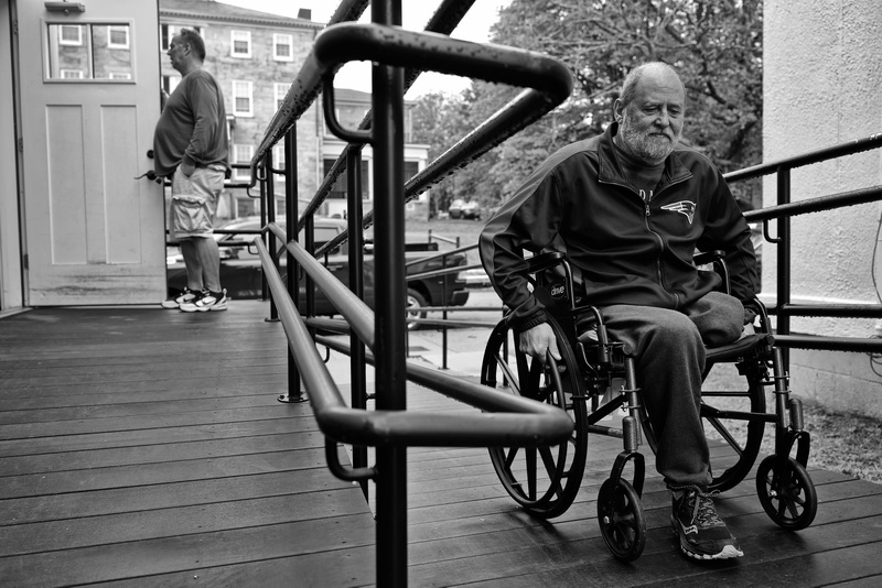 Veterans Transition House house manager, Robert Frazier, opens the door for Army veteran George Cettley who had his leg amputated after a recent failed surgery to his knee.  Mr Cettley was homeless and is now living at the new Veterans Transition House in New Bedford, MA.  PHOTO PETER PEREIRA