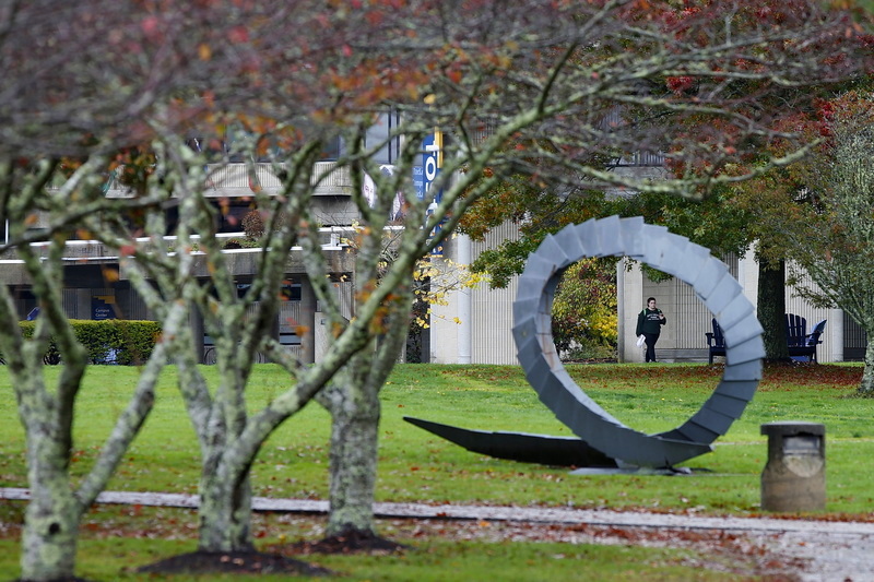 A UMass Dartmouth student walks past one of the many art installations found throughout the campus in Dartmouth, MA.  PHOTO PETER PEREIRA