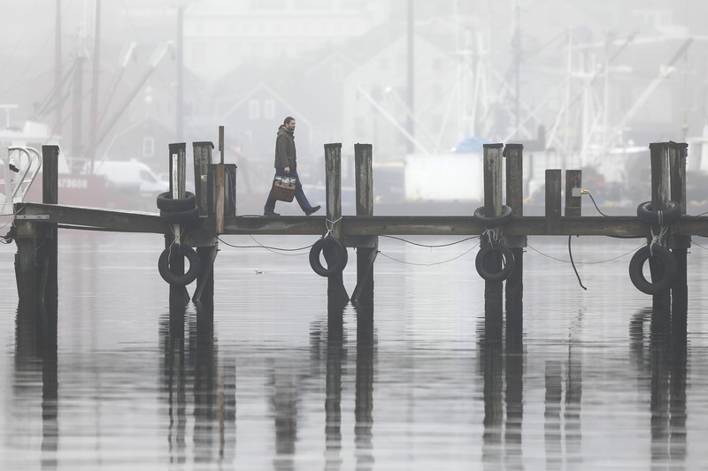 A man makes his way across the dock at Fleet Marina on Fish Island in New Bedford, MA on a foggy morning.  PHOTO PETER PEREIRA