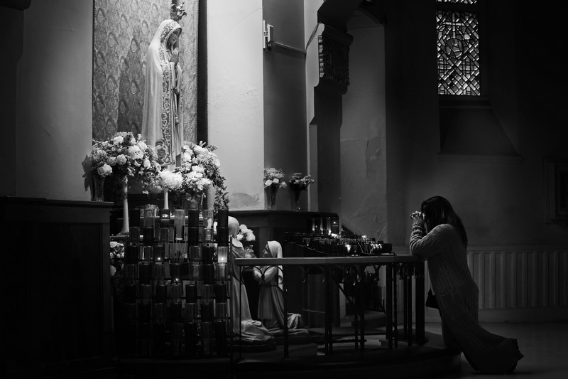 A woman prays in front of a statue of Our Lady of Fatima at the Saint Anne shrine in Fall River, MA.  PHOTO PETER PEREIRA