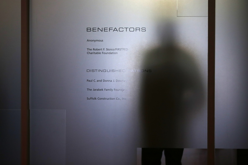 A man stands behind the glass walls of the UMass Dartmouth Carney Library during Massachusetts Governor Maura T. Healey's visit to learn more about the school's work around climate sustainability goals.  PHOTO PETER PEREIRA