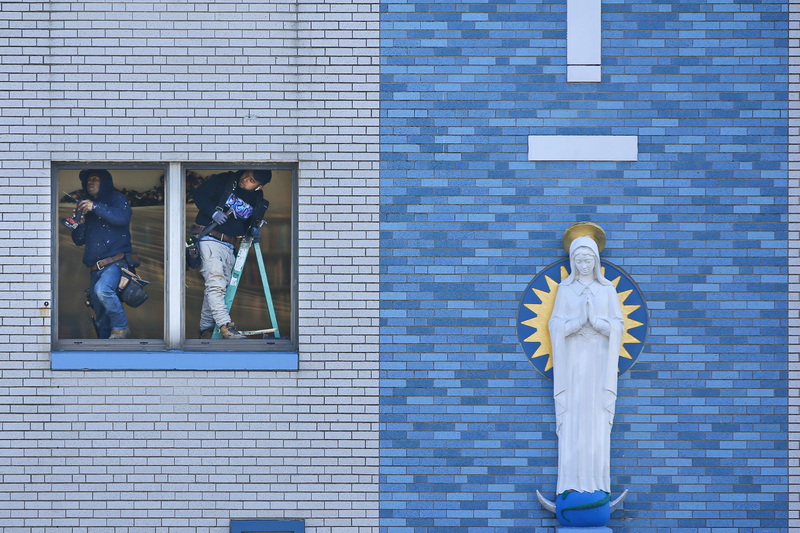 Two men replace the windows on the second level of Our Lady's Chapel in downtown New Bedford, MA.  PHOTO PETER PEREIRA