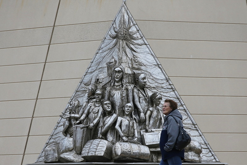 A woman passes a monument honoring 