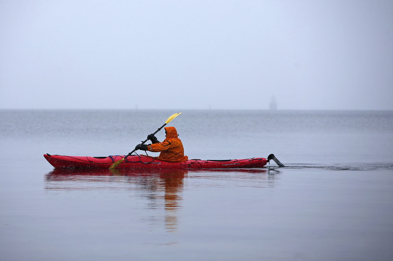 The Butler Flats lighthouse can barely be seen surrounded by fog in the distance as Antonio Pimenta braves the cold and falling snow to go for a kayak paddle around Fort Phoenix in Fairhaven, MA. PHOTO PETER PEREIRA