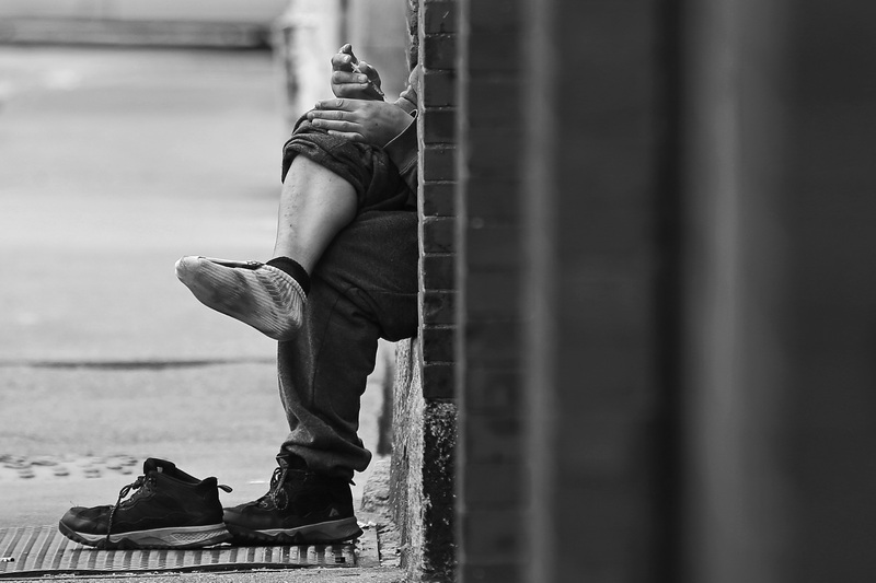 A man injects a syringe filled with heroin into his hand after injecting some into his leg in an alley in downtown New Bedford, MA.  PHOTO PETER PEREIRA