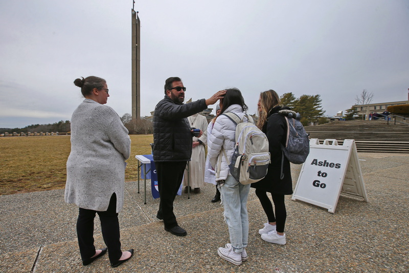 Rev. Scott Ciosek, Episcopal chaplain at UMass Dartmouth, administers ashes to students on Ash Wednesday in front of the UMass Dartmouth Campus Center.  PHOTO PETER PEREIRA