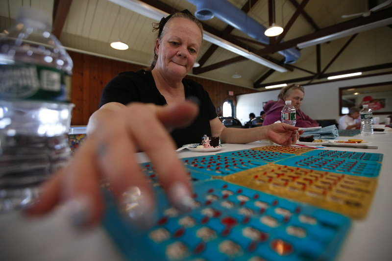 Debbie Gibson checks her cards for the called number as she and fellow seniors play the final round of Bingo at the Buttonwood Senior Center in New Bedford, MA before it becomes Adult Social Day Care Center.  PHOTO PETER PEREIRA