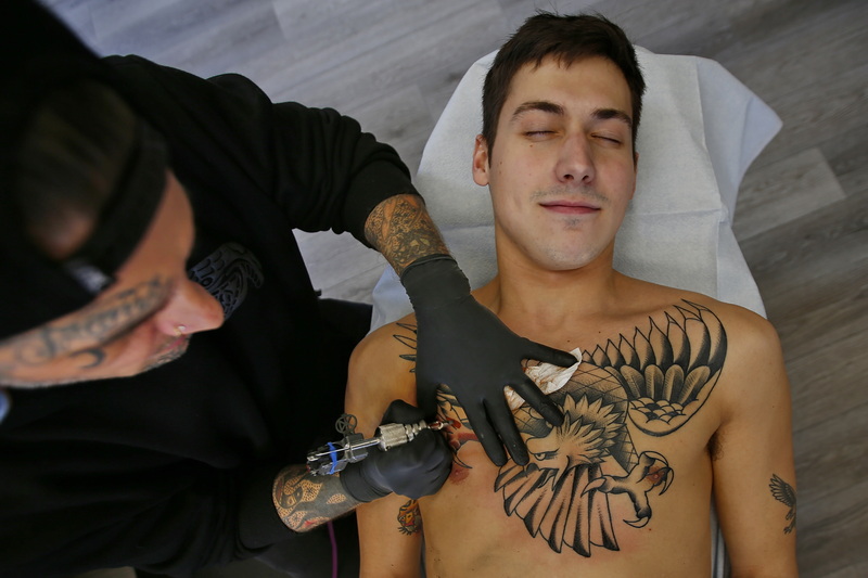 Steve Walters, tattoos one of his eagle designs on the chest of Noah Taylor at New Bedford Tattoo Co in New Bedford, MA. PHOTO PETER PEREIRA