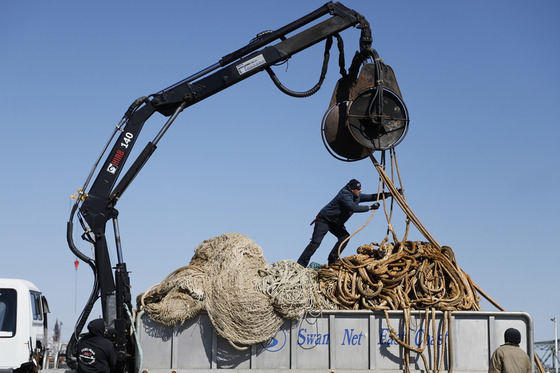 A Lund's Fisheries worker loads a pelagic species net from the F/V Retriever onto the bed of a truck on State Pier in New Bedford, MA.  This six hundred foot long net will be replaced by one which has already been repaired, as this one undergoes maintenance. PHOTO PETER PEREIRA