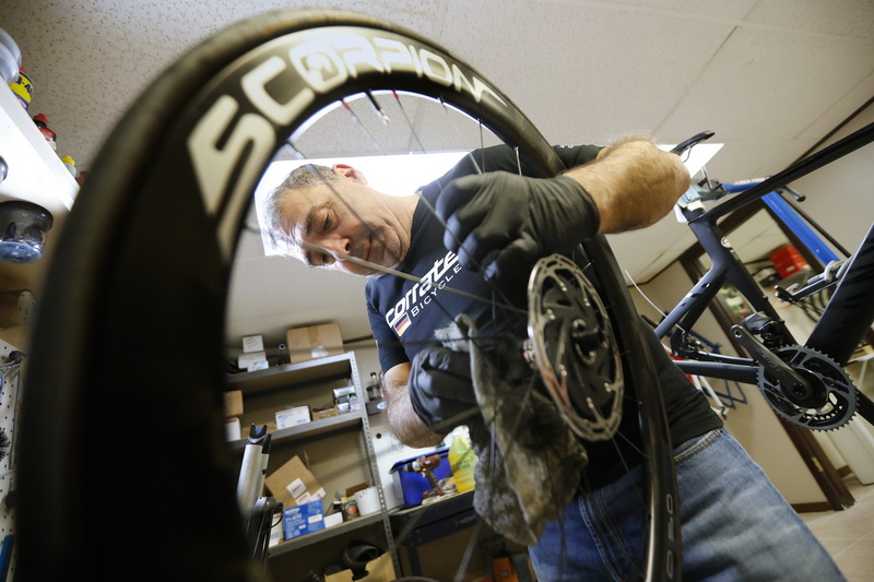 Tony Branco, owner of Scorpion Bike Wheels, puts the final touches on a set of carbon wheels he built for a customer, before installing them on the frame he is building seen in the background.  Mr. Branco started building high performance bicycle wheels in his basement and has now opened his own shop in the Jack Conway plaza on Route 6 in Dartmouth, MA.  PHOTO PETER PEREIRA