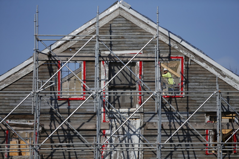 A construction worker is seen through the window of the historical faade being retained for the new apartment complex being constructed in downtown New Bedford, MA. PHOTO PETER PEREIRA