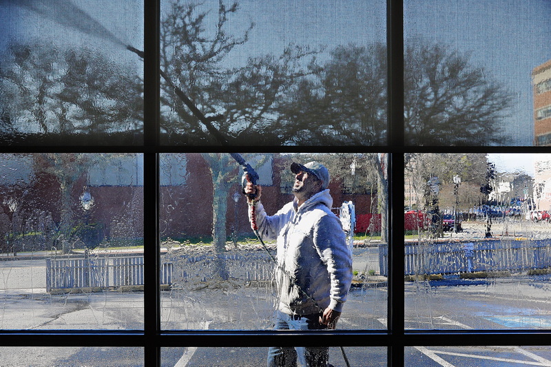 Cesar Pacheco of All Washed Up power washes the facade and windows of the newly opened Taunton Federal Credit Union branch on Union Street in New Bedford, MA.  PHOTO PETER PEREIRA