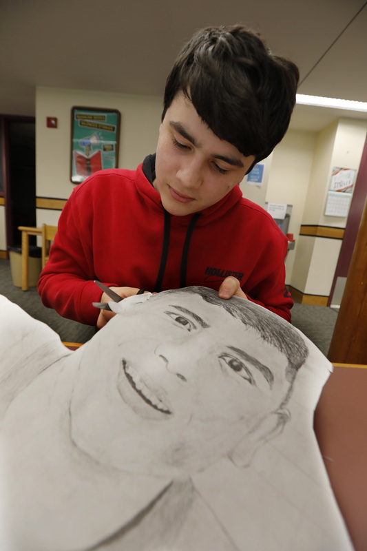 Dylan Pires, 14, cuts a self-portrait drawing he made. Apponequet High School art students prepare for the Annual Art Show on April 27 in the school's library.  PHOTO PETER PEREIRA