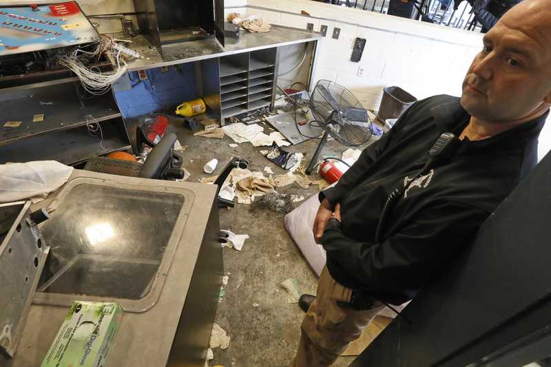 Bristol County investigative team member, Sgt. Glen Taber looks at the completely destroyed corrections officer station inside the unit at the Dartmouth House of Correction damaged by inmates two weeks ago. PHOTO PETER PEREIRA