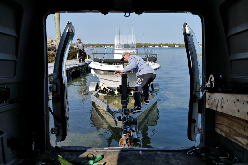 Juan Diaz pushes his boat from the boat ramp on East Rodney French Boulevard in New Bedford, MA as seen from the inside of his van. PHOTO PETER PEREIRA