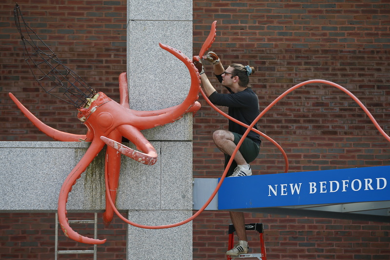 Enzo Cruz removes the iconic squid sculpture from the entrance of the Whaling Museum in New Bedford.  The weather had taken a toll on the sculpture by local artist Erik Durant and was needed to be removed. PHOTO PETER PEREIRA