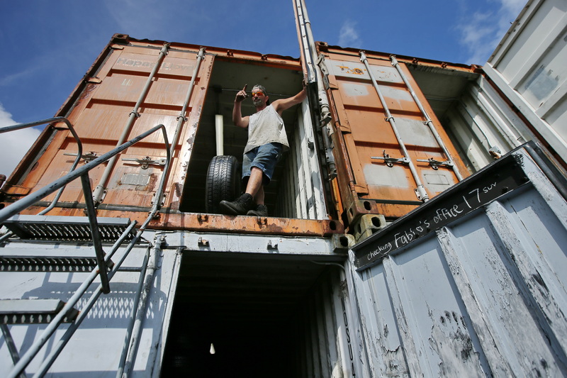 Russell Santos of Joe's Tire on Acushnet Avenue in New Bedford, MA calls out from the second level of storage containers with a tire he found for a customer. PHOTO PETER PEREIRA