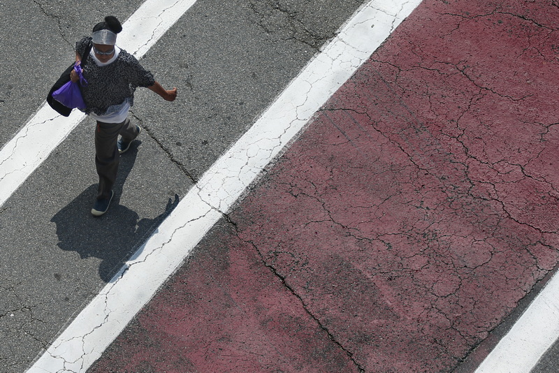 A woman crosses Acushnet Avenue in downtown New Bedford, MA between the colorful crosswalk lines. PHOTO PETER PEREIRA