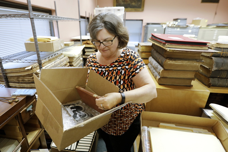 New Bedford Public Library Director, Olivia Melo, pulls the 120 year overdue book from the box shipped to New Bedford from West Virginia University Library. An Elementary Treatise on Electricity by James Clerk Maxwell was returned to the West Virginia University library one hundred years after it was taken out of the New Bedford Public library in 1903. PHOTO PETER PEREIRA