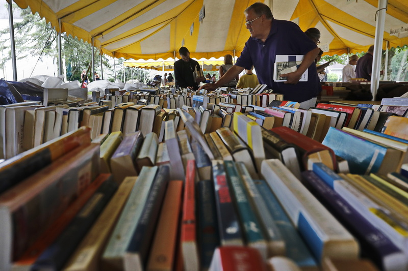 People browse the vast collection of books for sale at the Annual Book Fair in front of the Macomber Community House on Main Road in Westport, MA.  The fair will run daily from 9am-7pm until Sunday July 16th.