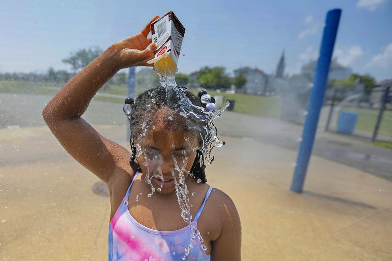 Ja-Veah Cheney, 9, pours water over her head, taking shelter from the sweltering heat at the splash pad station at Riverside Park in New Bedford, MA. PHOTO PETER PEREIRA