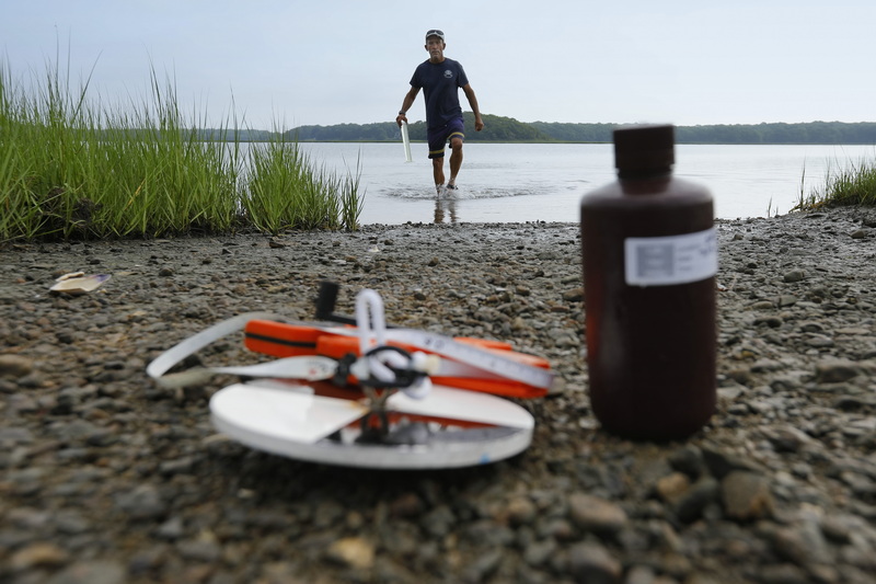 Jamie Bogart of the Lloyd Center for the Environment in Dartmouth, MA emerges from the Little River with a water sample to test for nutrients, the first of four tests which will be done during summer months. PHOTO PETER PEREIRA