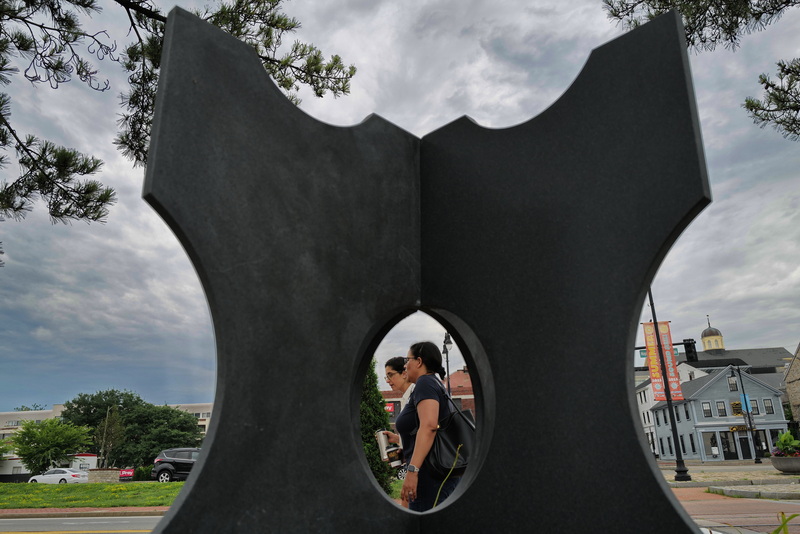 Two women walk past Solidarity by R. Douglass Rice installed on MacArthur Drive in New Bedford, MA. The tenth annual Seaport Art Walk opened on New Bedford's waterfront on July 13th and will run until the end of October. PHOTO PETER PEREIRA