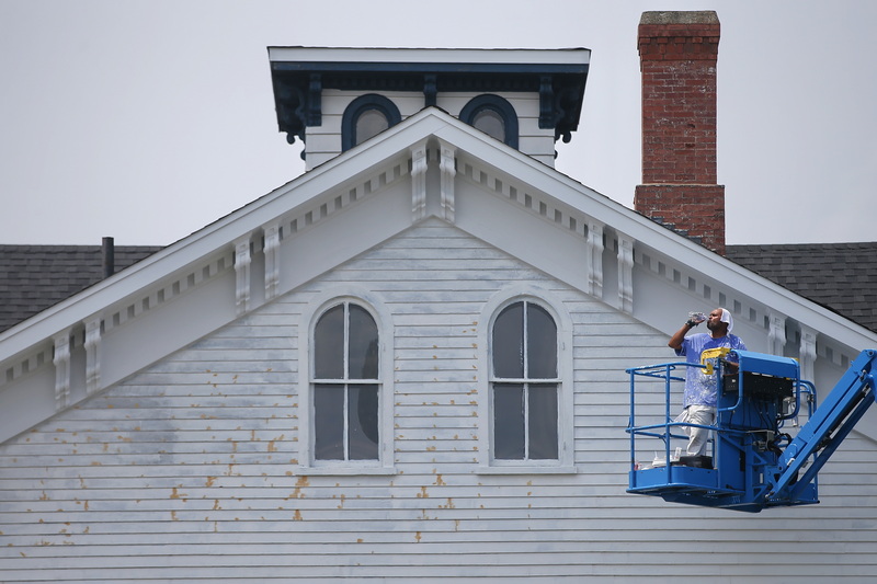 A painter working on a home in downtown New Bedford, MA takes a moment to cool of from the sweltering heat by drinking water. PHOTO PETER PEREIRA