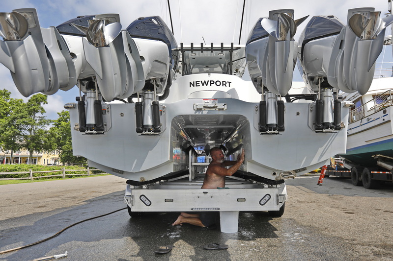 Steve Clark of Southeastern Marine Transport cleans the inside of a catamaran power boat he just delivered to be put in the water in Mattapoisett, MA. PHOTO PETER PEREIRA