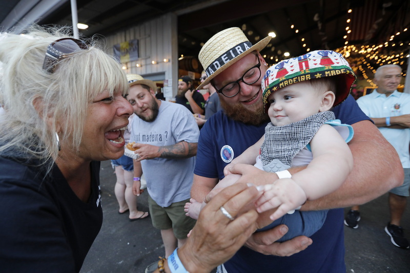 Debbie Fernandes is overcome with emotion as she runs into her great-nephew Gates Fernandes, 8 months being held by his father Cory Fernandes during the first night of the Feast of the Blessed Sacrament held at Madeira Field in New Bedford, MA. PHOTO PETER PEREIRA