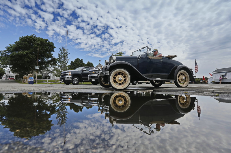 A man drives his Model-A Ford past a large puddle on the wharf in Mattapoisett, MA. PHOTO PETER PEREIRA