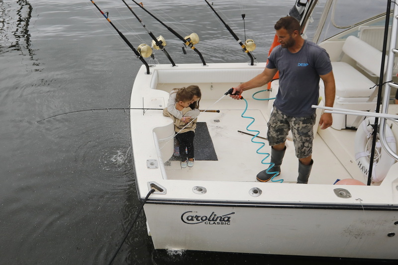 Kendall Birch, 7, hugs her little brother Wesley Ross, 3, after he cast a line in the water upon visiting their father Luke Ross seen washing the deck of his boat after arriving in Fairhaven from a tuna fishing voyage. PHOTO PETER PEREIRA