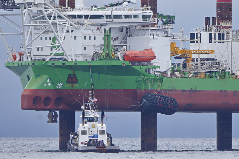 The Earl W Redd tugboat is dwarfed by the Danish wind turbine installation vessel, Sea Installer, at the offshore wind turbine field off Nantucket, MA. PHOTO PETER PEREIRA