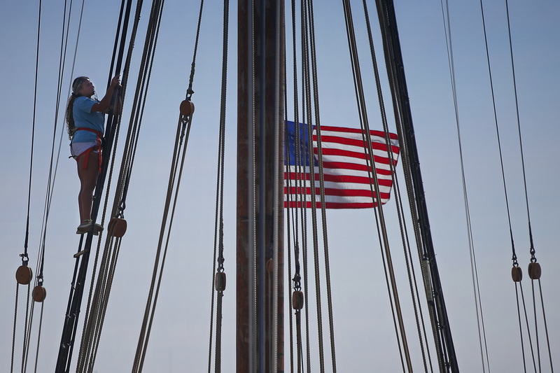 A crewmember of the Ernestina-Morrissey works on the rigging of the iconic schooner high above the State Pier in New Bedford, MA. PHOTO PETER PEREIRA