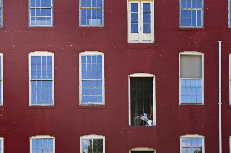 A man takes a break with a view from the opened door at a building on Elm Street in New Bedford, MA.  PHOTO PETER PEREIRA