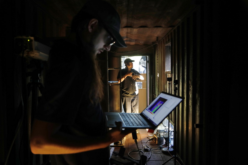 Joe Carrock, a Telops field application engineer, looks at the thermal imagining on his laptop as Mike Monaco of The Hazmat Guys, prepares a battery to be destroyed during the lithium battery fire demonstration hosted by New Bedford Fire Department.  PHOTO PETER PEREIRA