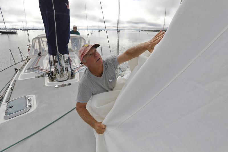 Scott Belliveau who is currently living in South Carolina had his friends Bob Warren, seen here removing the headsail, and Fran Grenon prepare his sailboat moored in Mattapoisett, MA harbor for the possible hurricane Lee making landfall at the end of the week.  PHOTO PETER PEREIRA