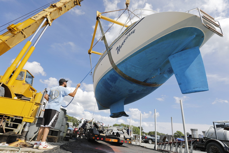 Cad Richard and fellow Davis & Tripp Marina and Boat Yard crews pull a sailboat named Hurricane from the waters of Padanaram harbor in Dartmouth, MA in preparation for the arrival of hurricane Lee. PHOTO PETER PEREIRA