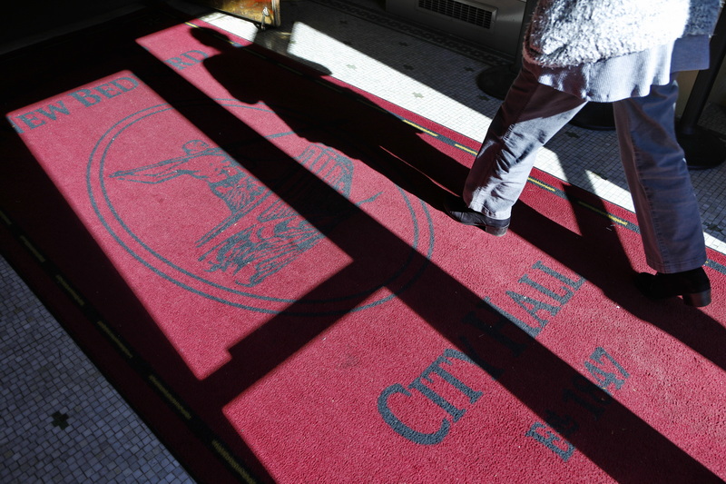 A woman cast a shadow on the rug as she makes her way into New Bedford City Hall established in 1847. PHOTO PETER PEREIRA