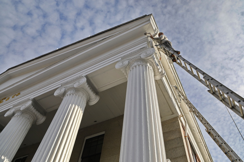 A painter hangs high above N Front Street in New Bedford as he paints the frieze of the iconic J.J. Best Banc & Co. building in downtown New Bedford. PHOTO PETER PEREIRA