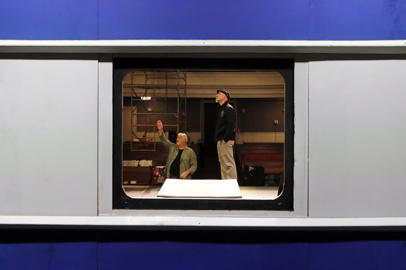 Paul Sardinha, who will play Monsieur Bouc, and Eric Paradis, Your Theater community liaison, are seen through a train window set as they discuss lighting for upcoming the Murder on the Orient Express, the first show by Your Theater at the new Steeple Playhouse inside the former First Baptist Church on William Street in New Bedford, MA. PHOTO PETER PEREIRA